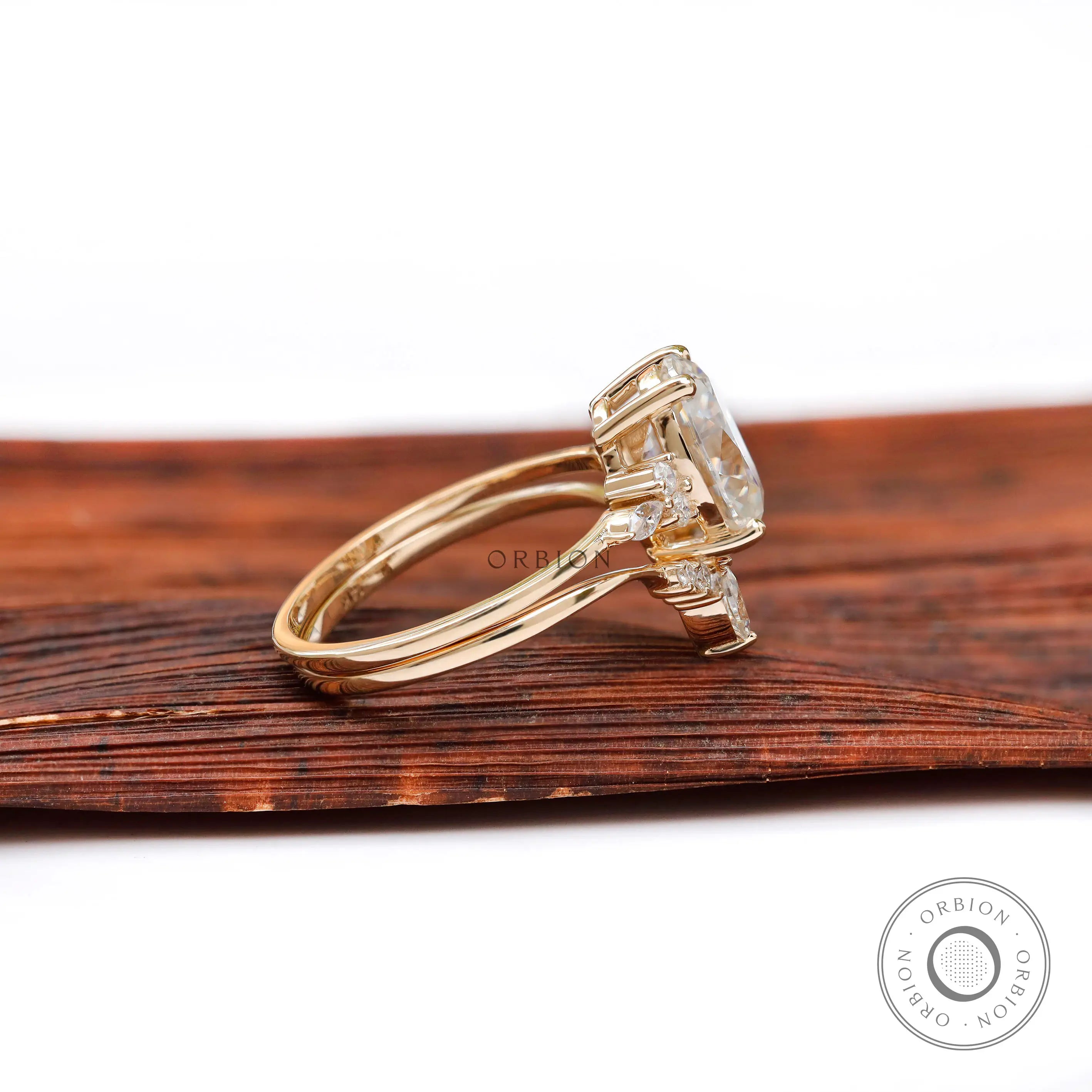 Side view of oval moissanite cluster ring and curved wedding band