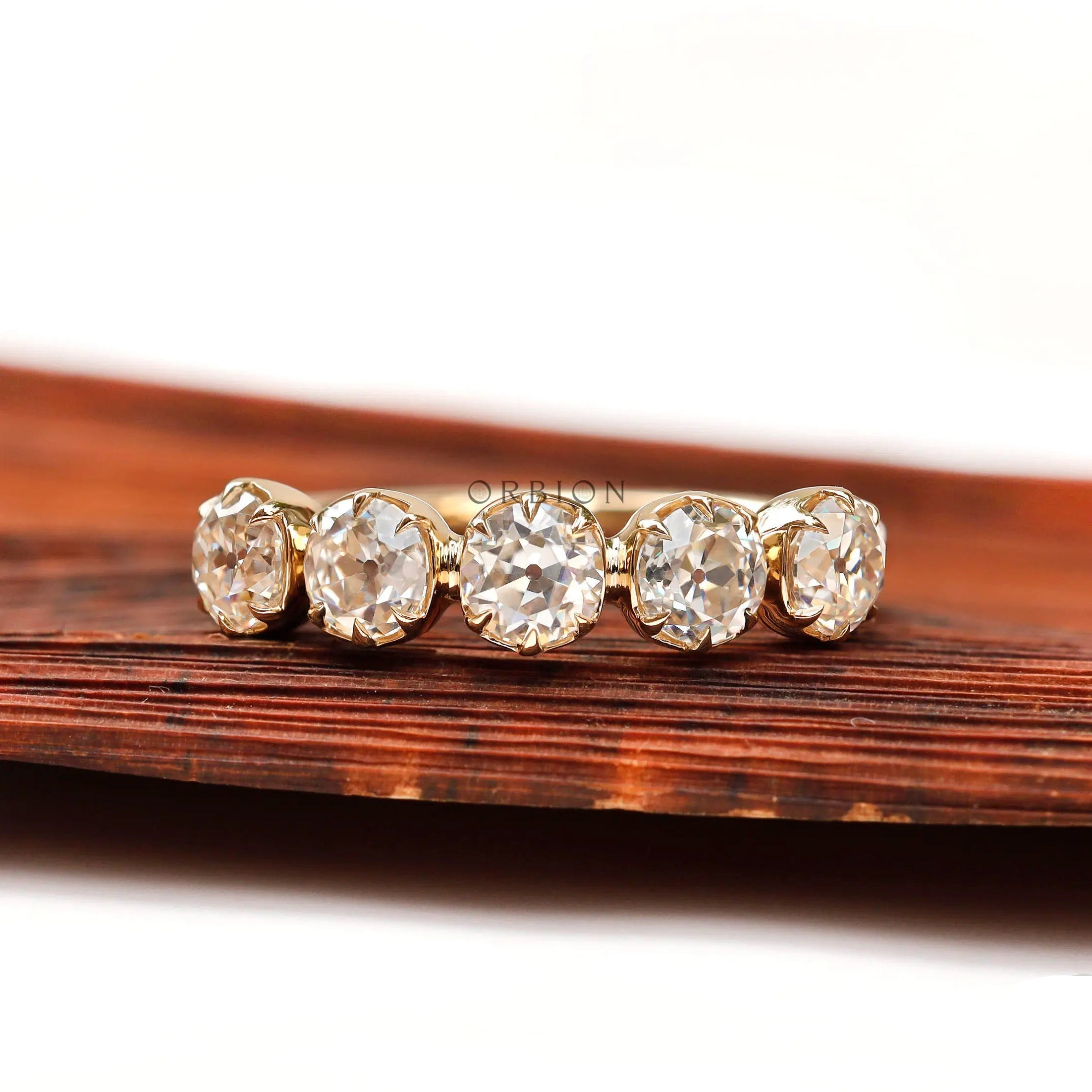 Front view of five stone round moissanite band