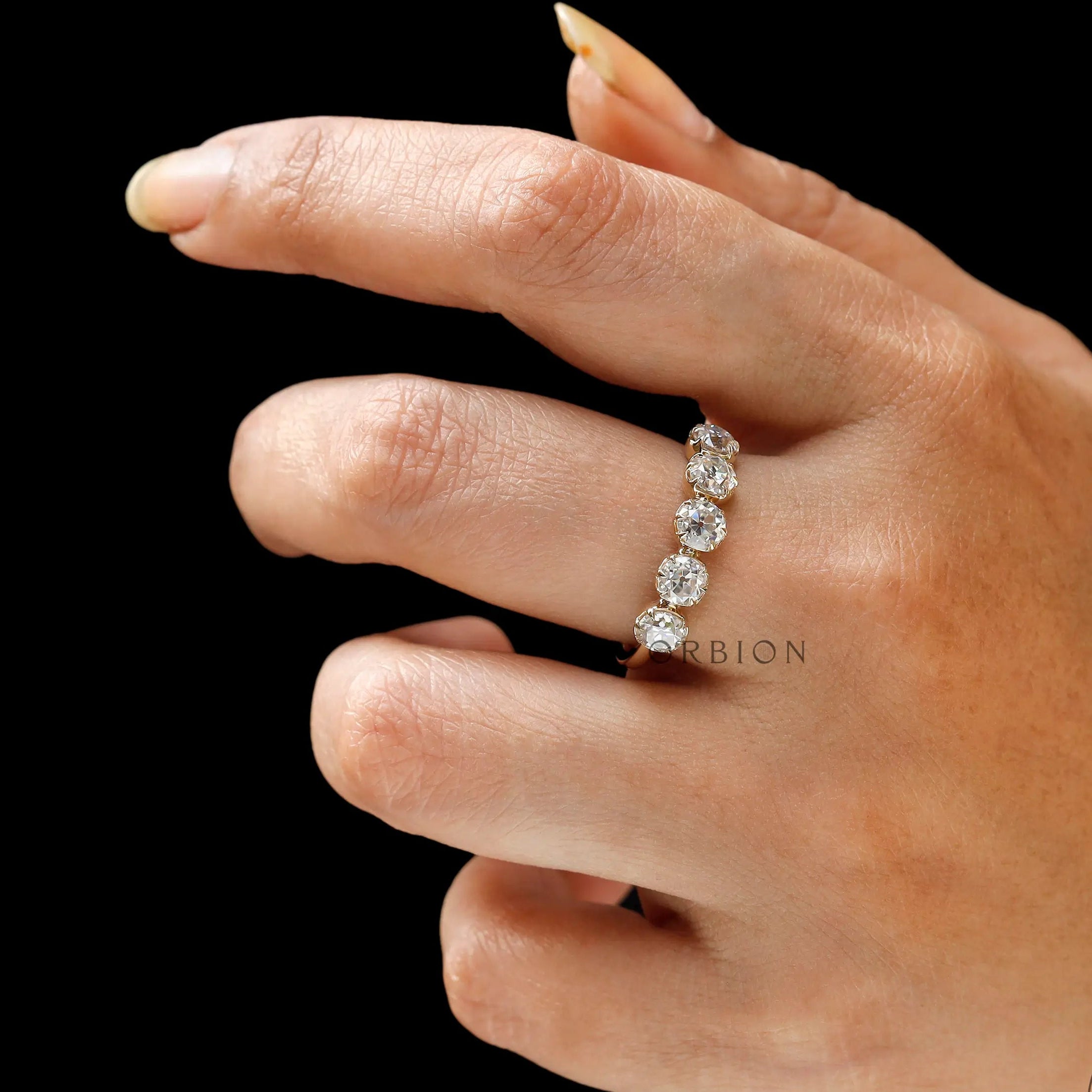 Lifestyle view of five stone yellow gold band