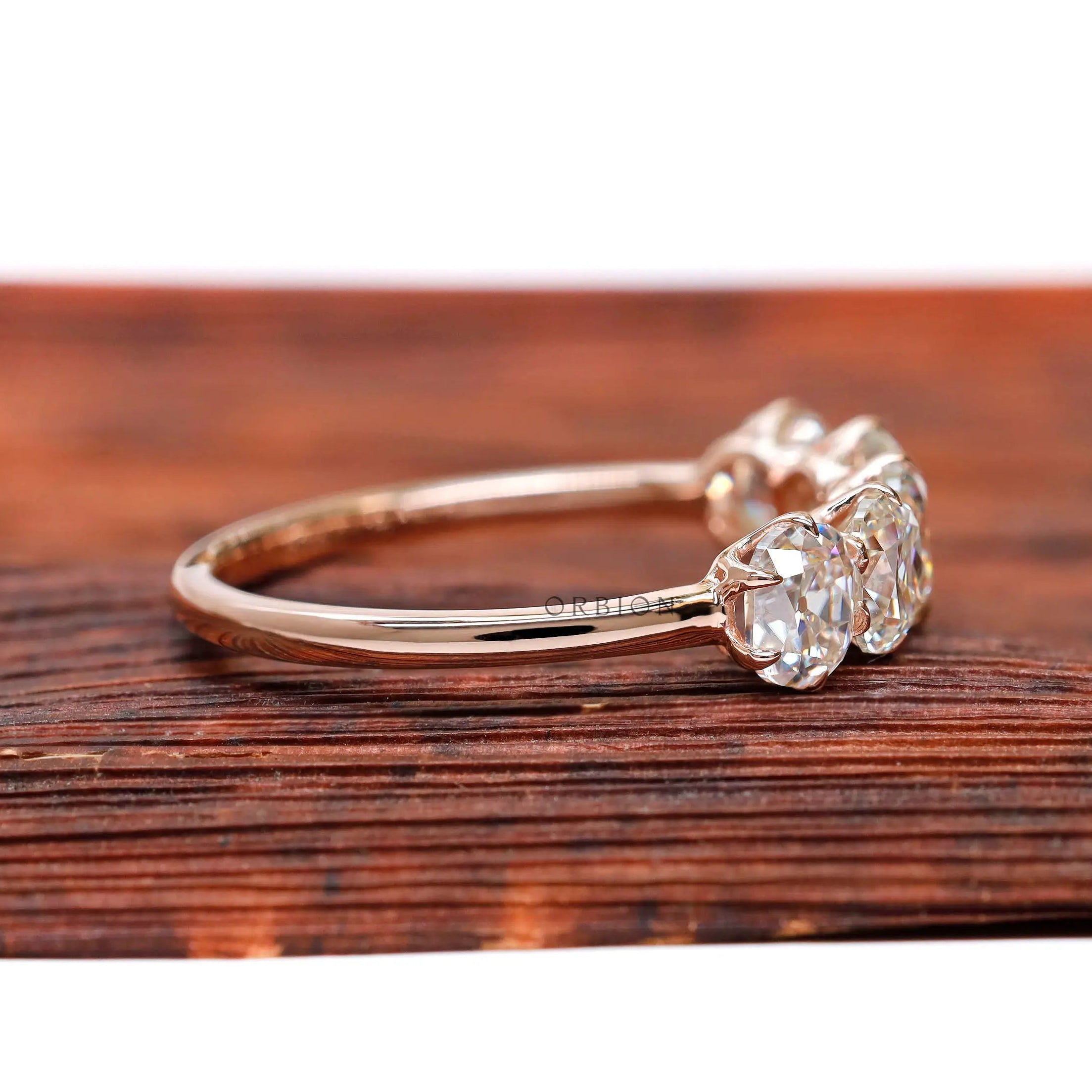 Side profile of elongated cushion moissanites in rose gold band