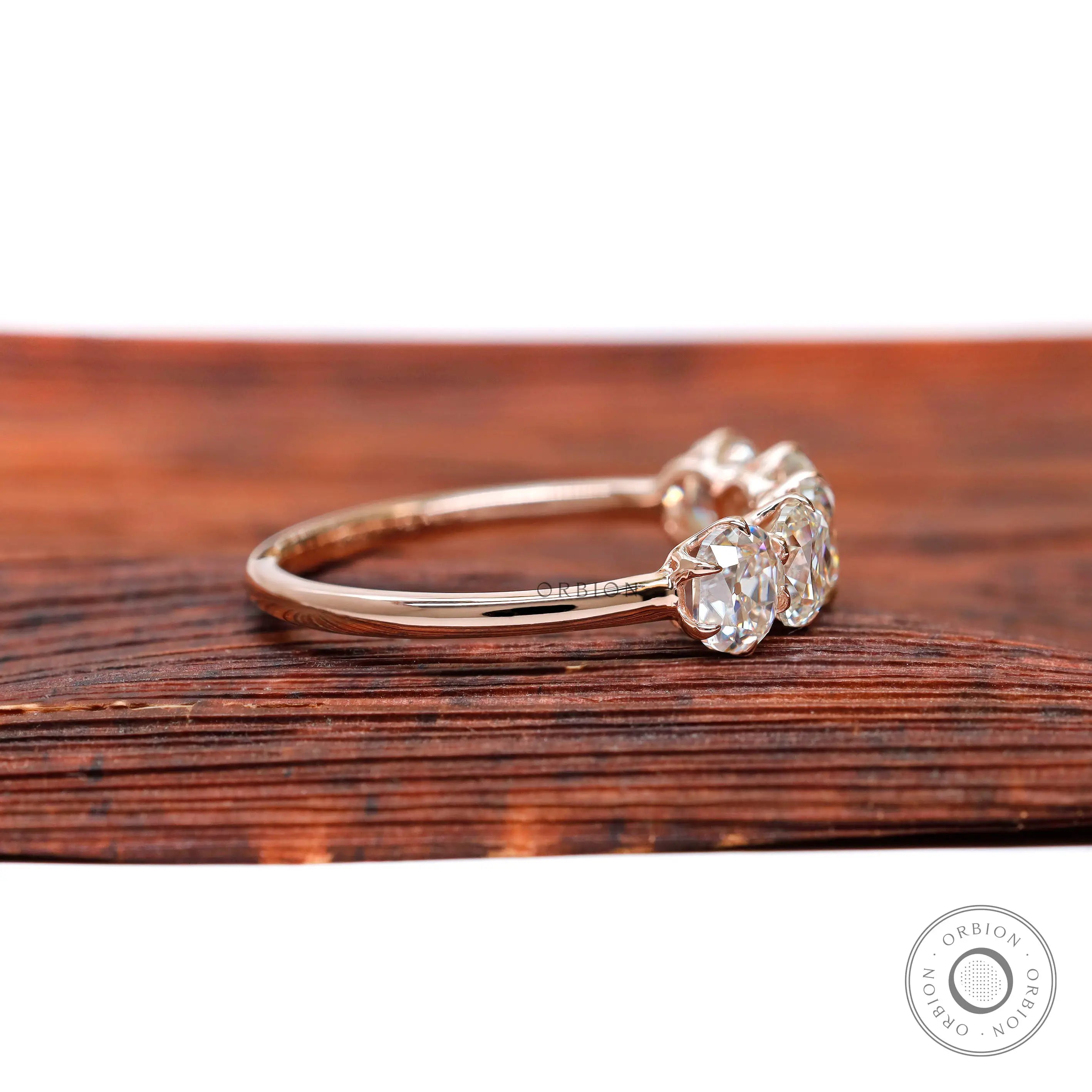 Side profile of elongated cushion moissanites in rose gold band