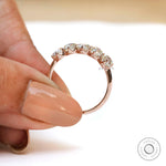 Elongated cushion moissanite band held between fingers