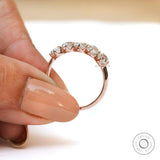Elongated cushion moissanite band held between fingers