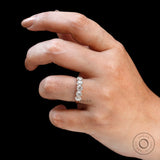 Hand close-up showing five elongated cushion moissanites sparkle
