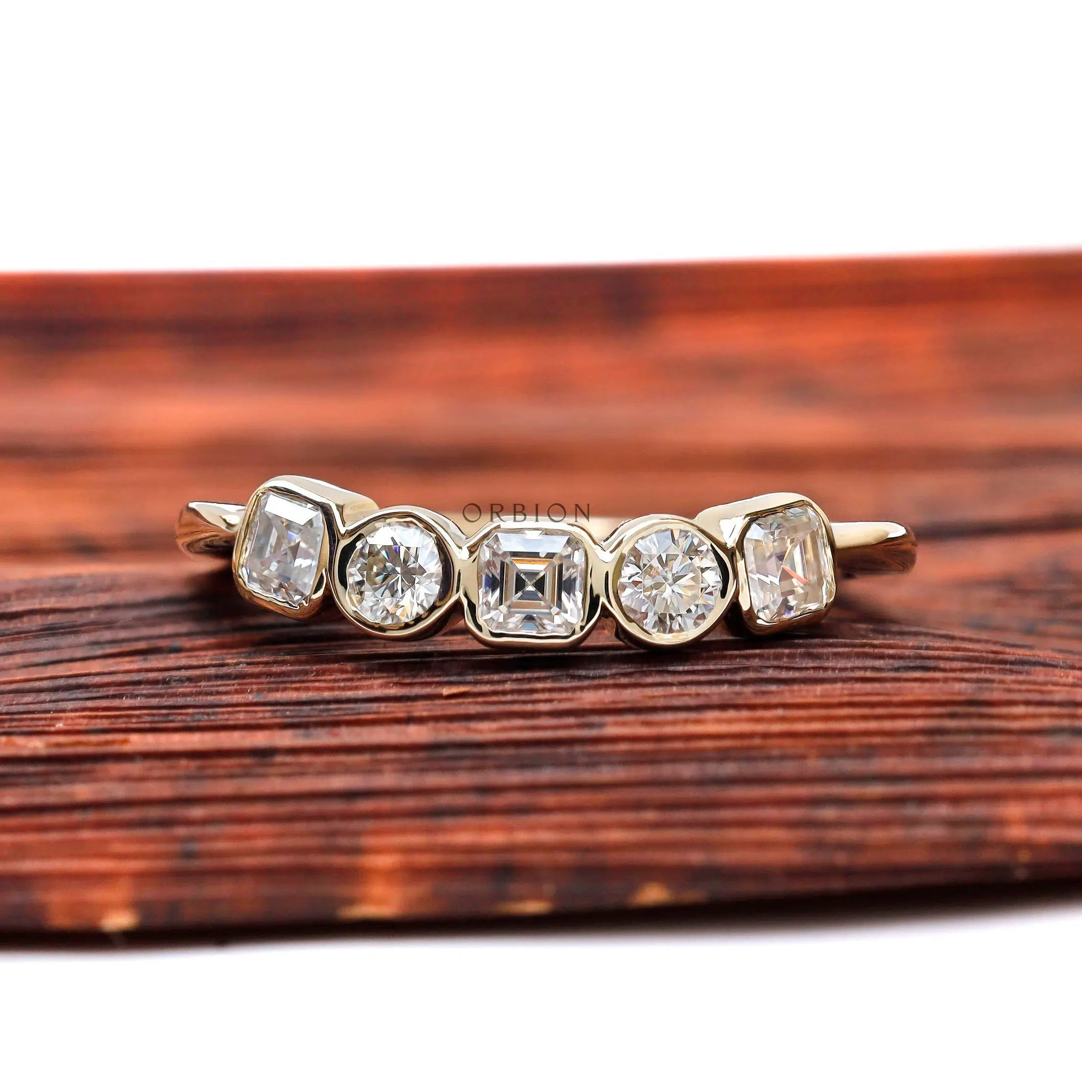 Top view of five-stone moissanite band with asscher center and round accents.