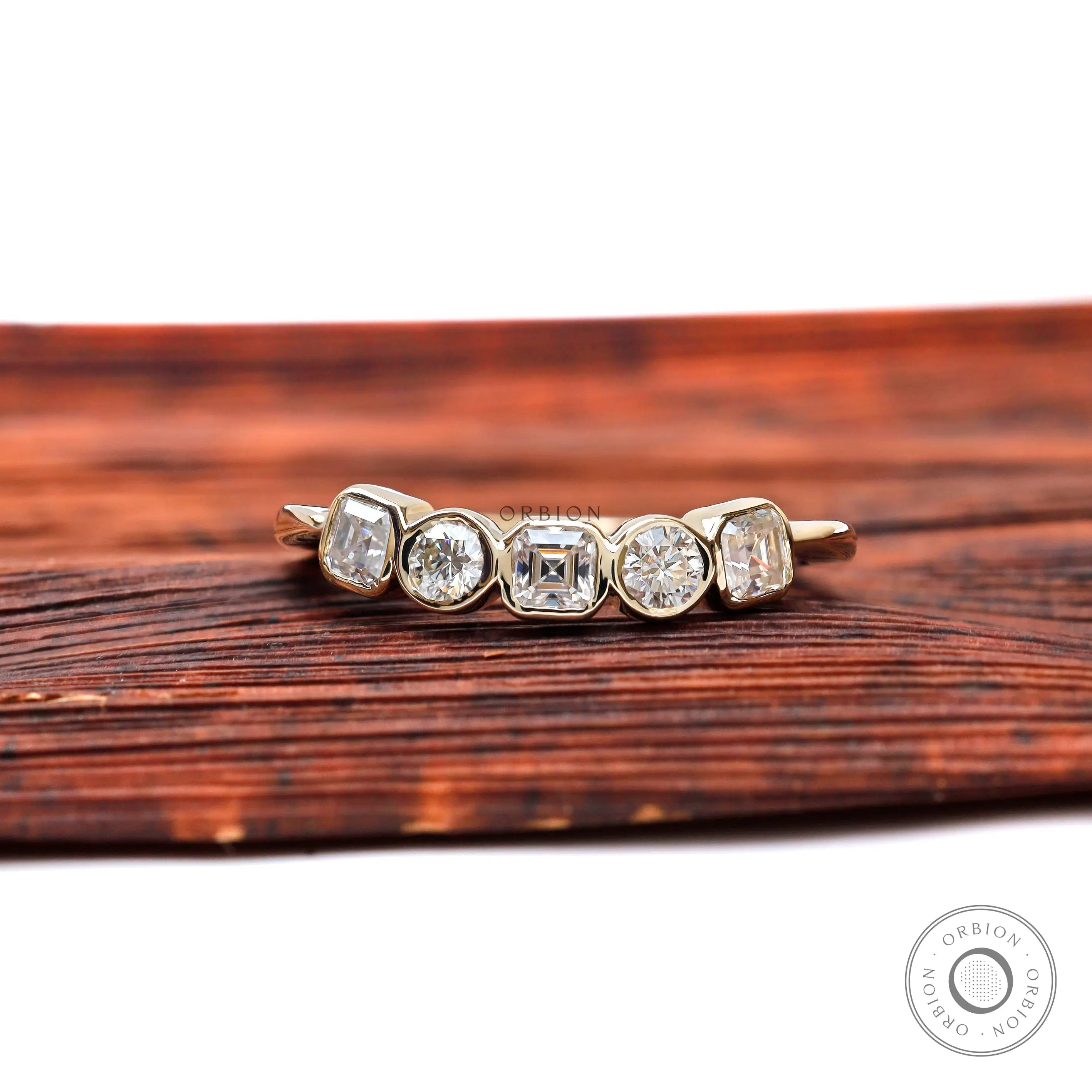 Top view of five-stone moissanite band with asscher center and round accents.