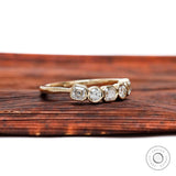 Angled top view showing bezel-set alternating Asscher and round stones.