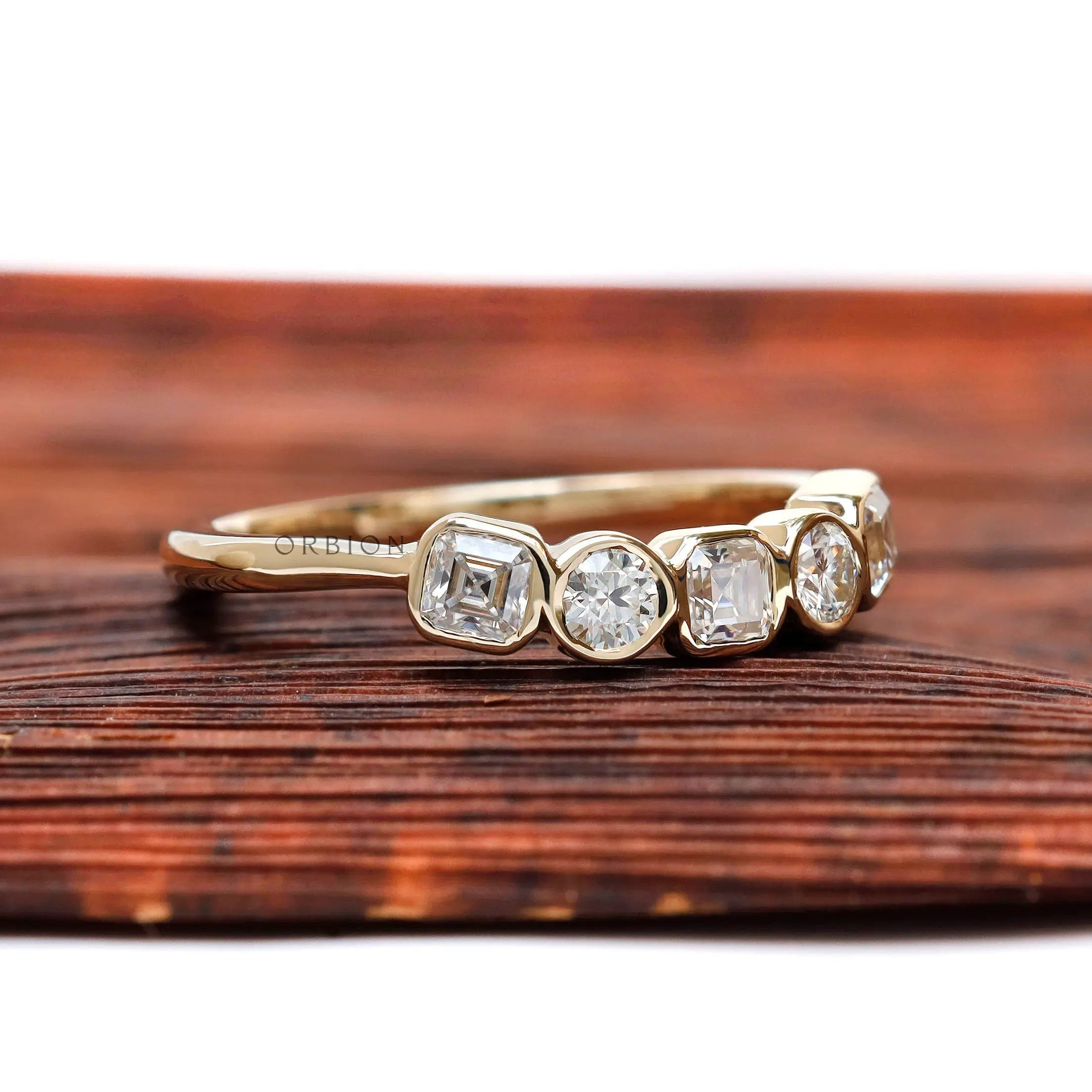 Angled top view showing bezel-set alternating Asscher and round stones.