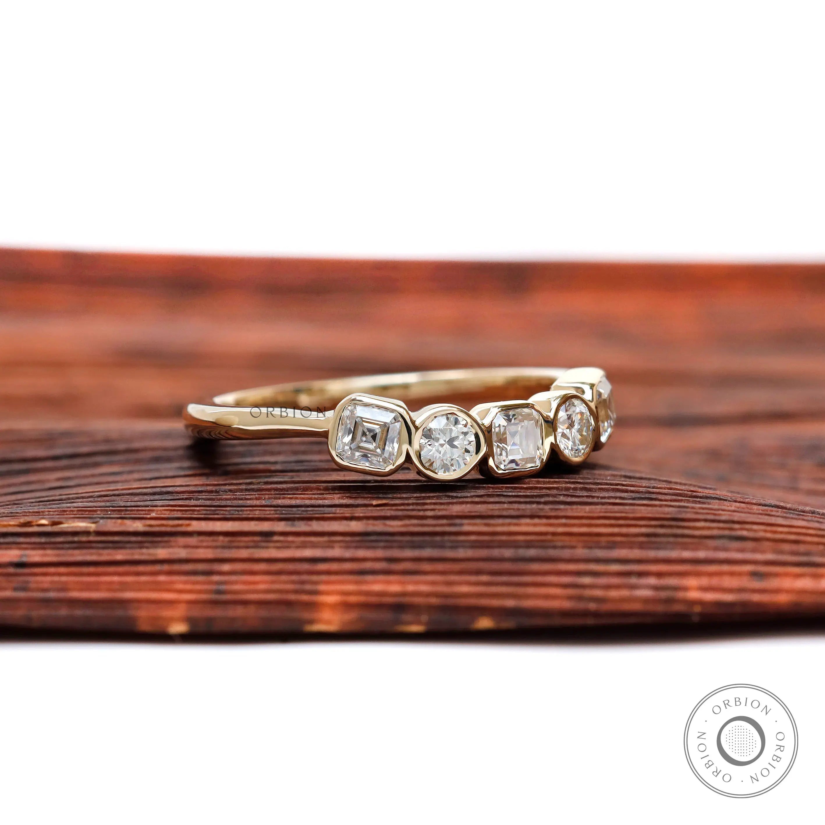 Angled top view showing bezel-set alternating Asscher and round stones.