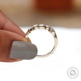 Profile on hand showing tapered band and sparkling five-stone line.
