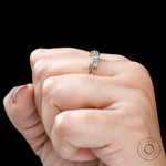 Top view on hand showing five-stone alternating moissanite design.