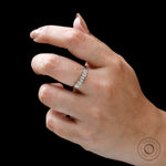 Close-up on hand showing refined bezels and minimalist stacking style.