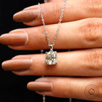 Close-up of pendant held against hand showing size and brilliance