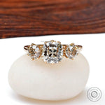 Front view three-stone vintage ring on white pebble.