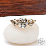 Front view three-stone vintage ring on white pebble.