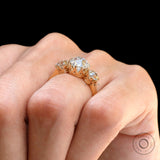 On-hand side profile highlighting elevated three-stone setting.
