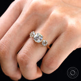 On-hand top view showing trilogy stones across band.