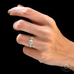 Lifestyle hand pose showing three-stone ring on black.