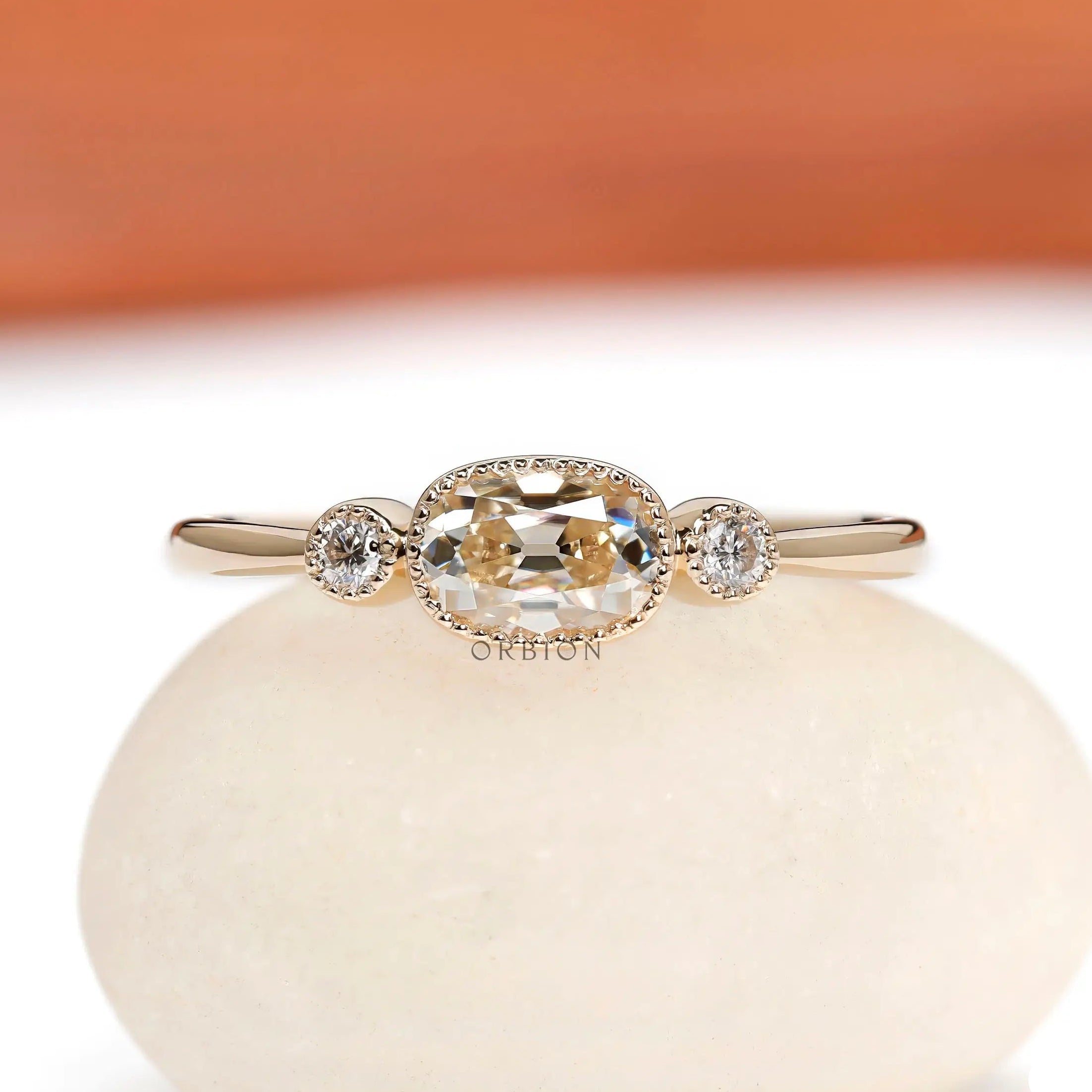 Front view of elongated cushion moissanite ring with round side stones