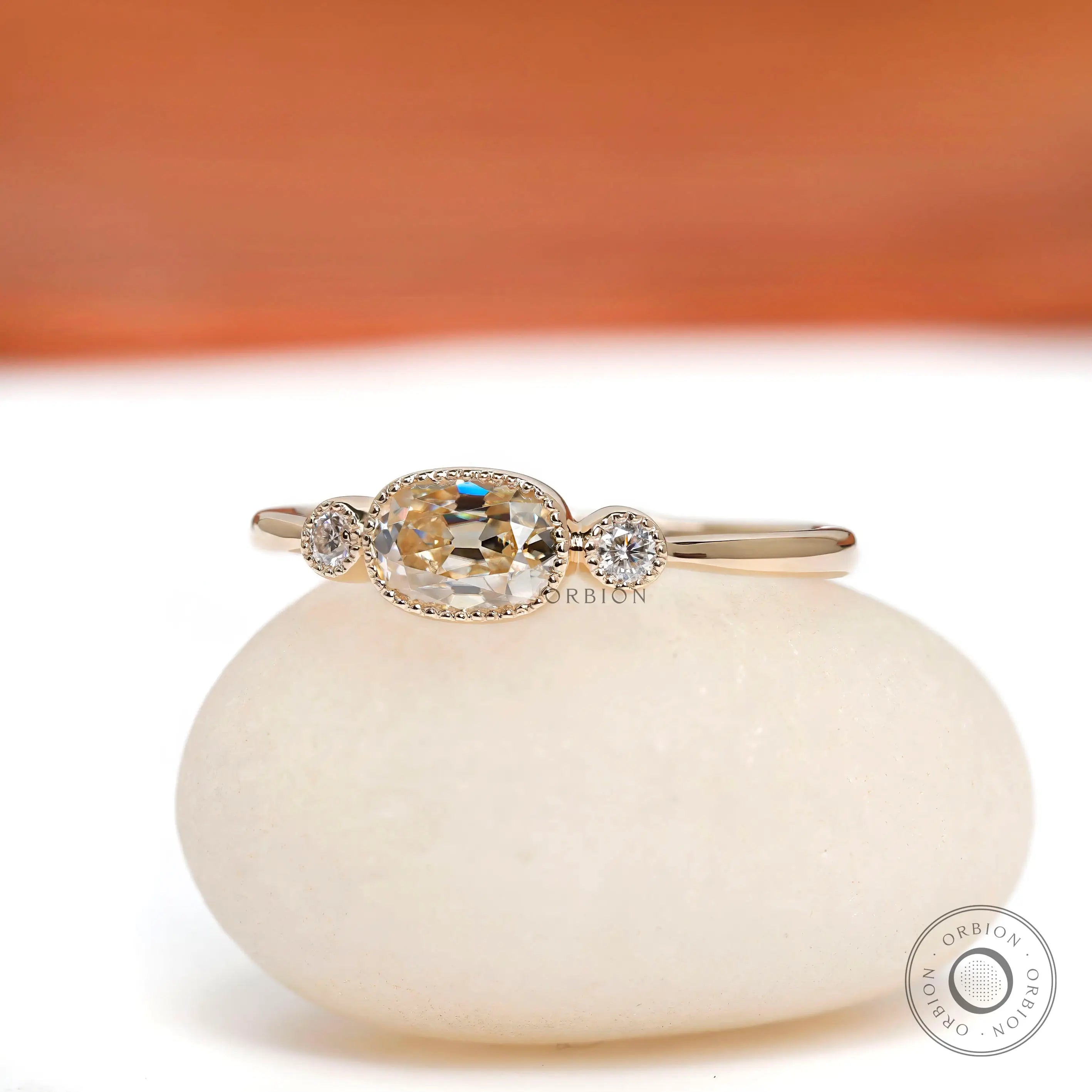 Elongated cushion moissanite three stone ring with milgrain bezel in yellow gold