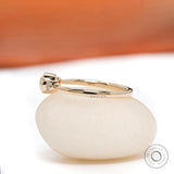 Side profile of three stone moissanite engagement ring in yellow gold