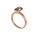 Three-quarter angled view of emerald grey moissanite with rose gold claws.