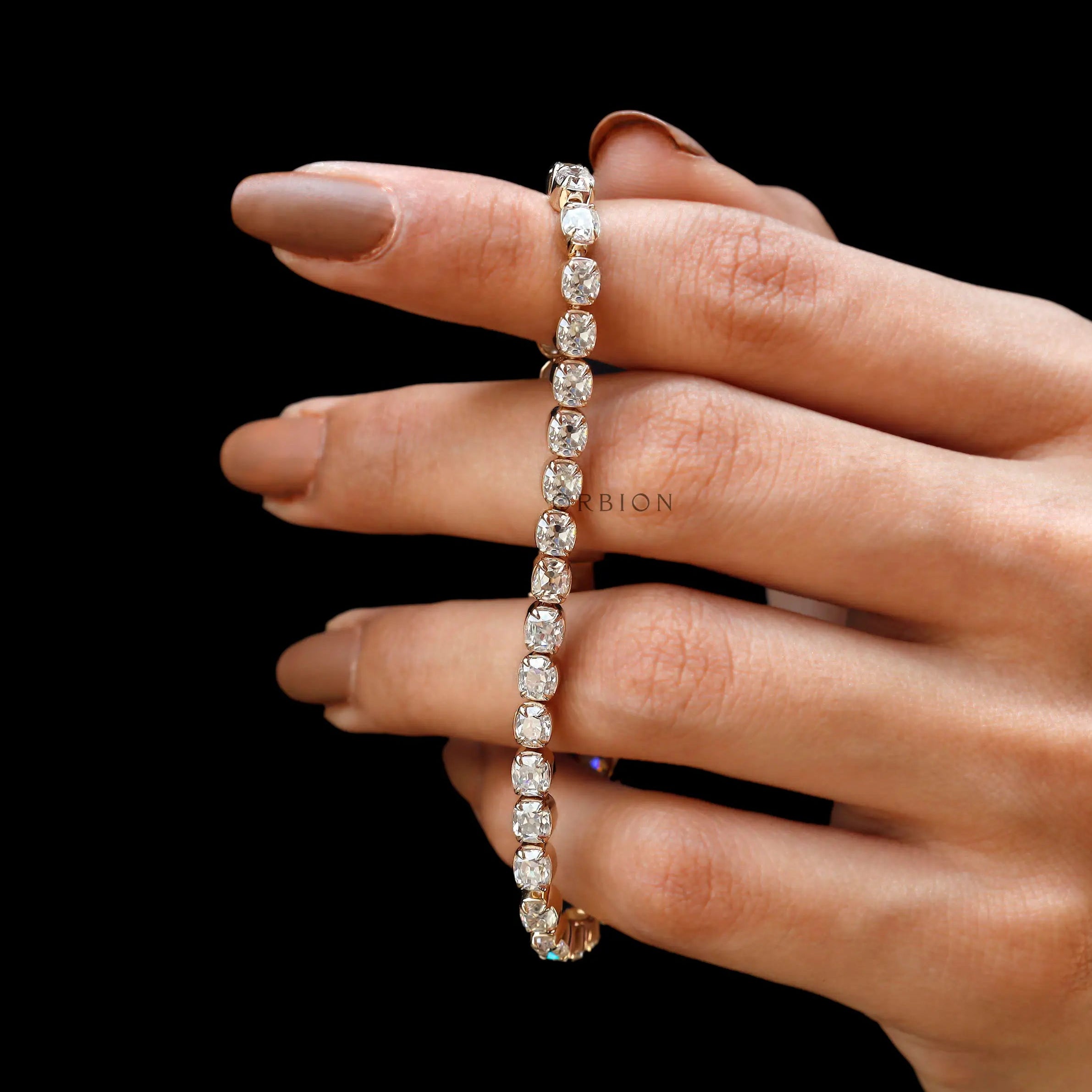 Antique OMC cushion moissanite tennis bracelet styled across fingers