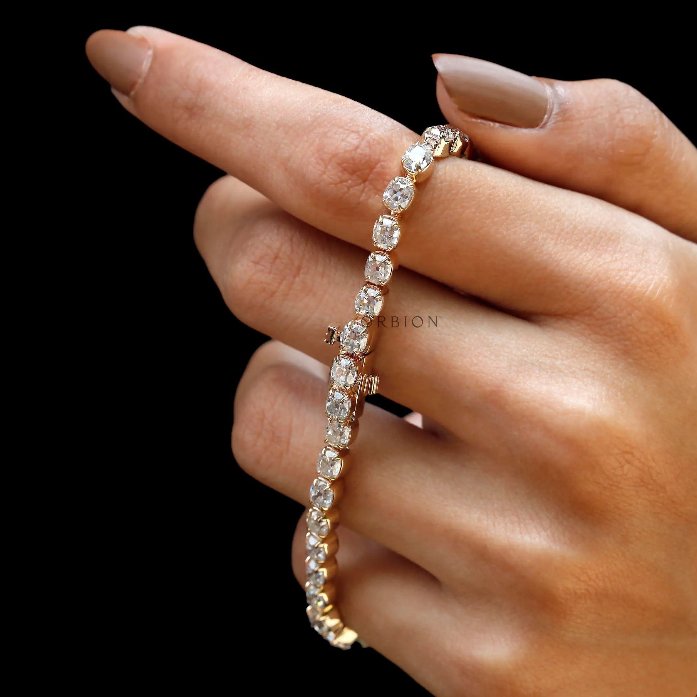Side angle view of OMC cushion moissanite tennis bracelet in yellow gold