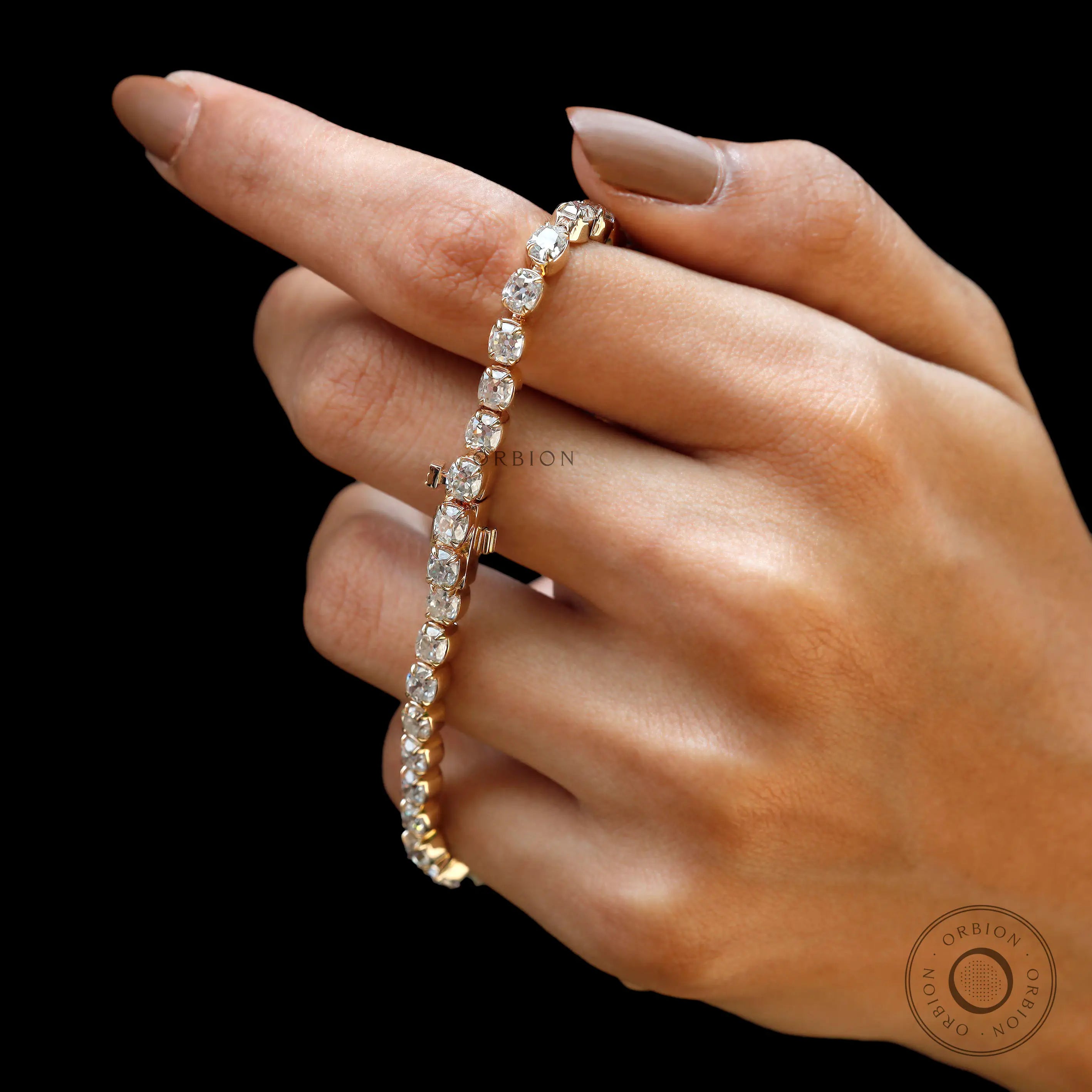 Side angle view of OMC cushion moissanite tennis bracelet in yellow gold