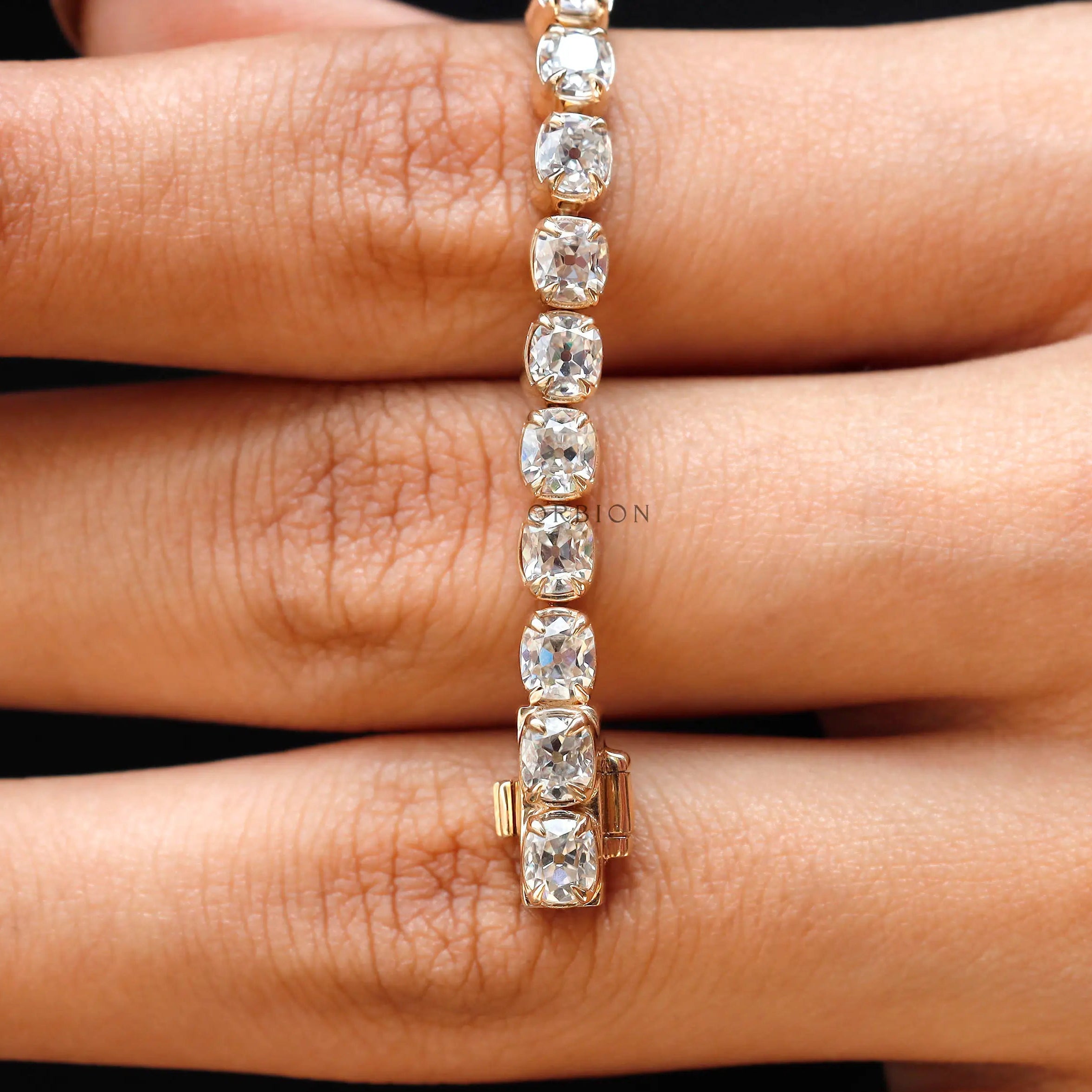 Closeup of antique OMC cushion moissanite links in yellow gold
