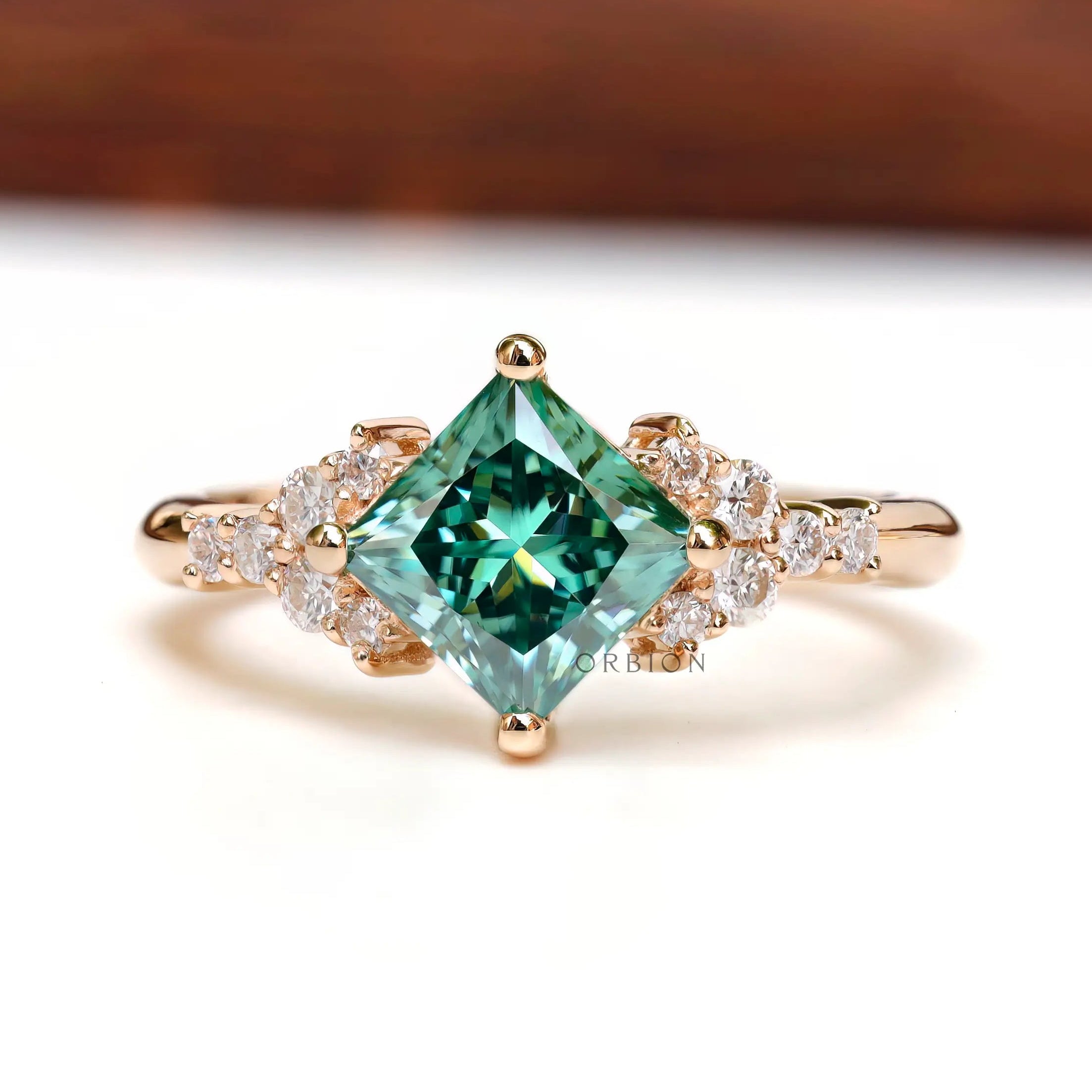 Front view of the princess-cut green moissanite engagement ring.