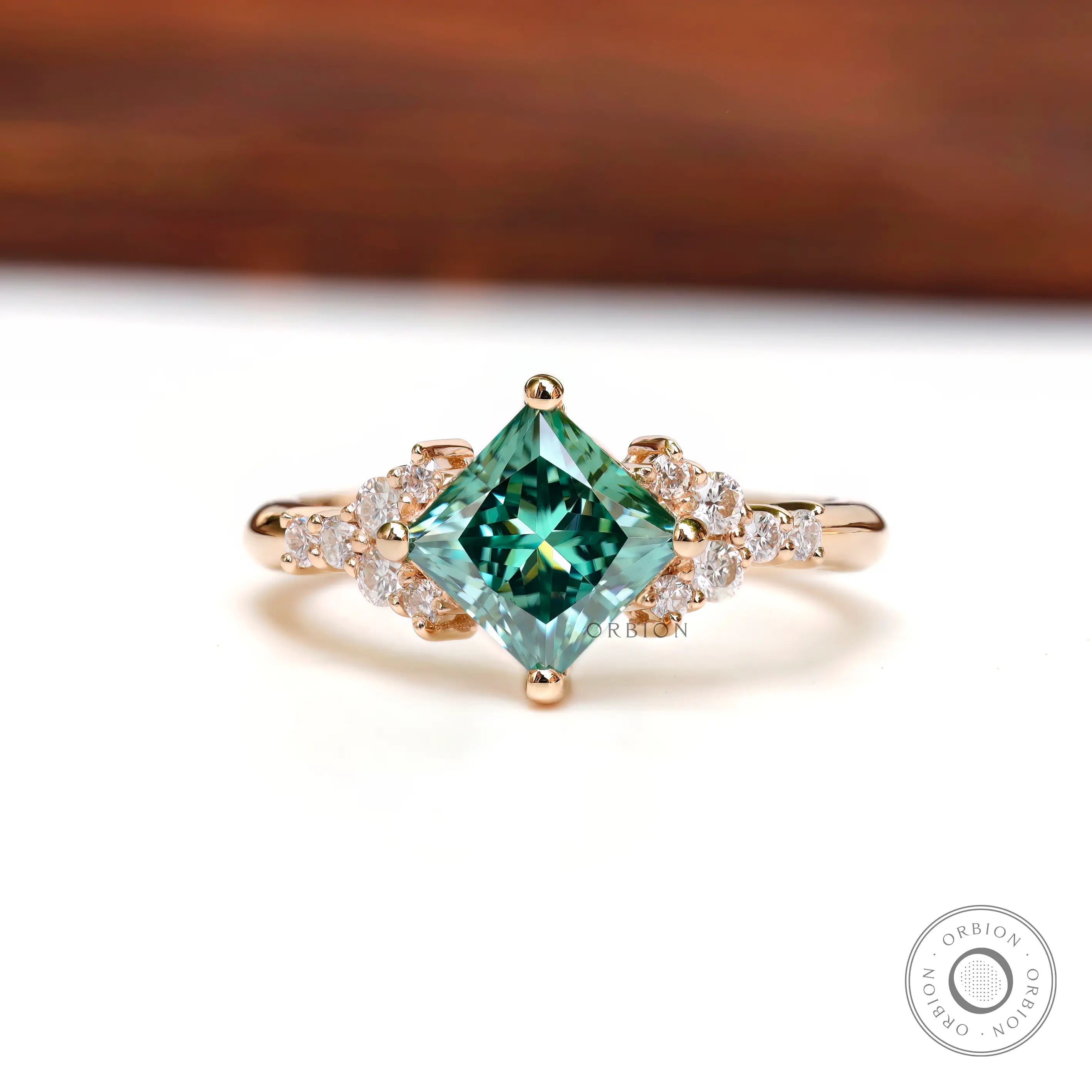 Front view of the princess-cut green moissanite engagement ring.