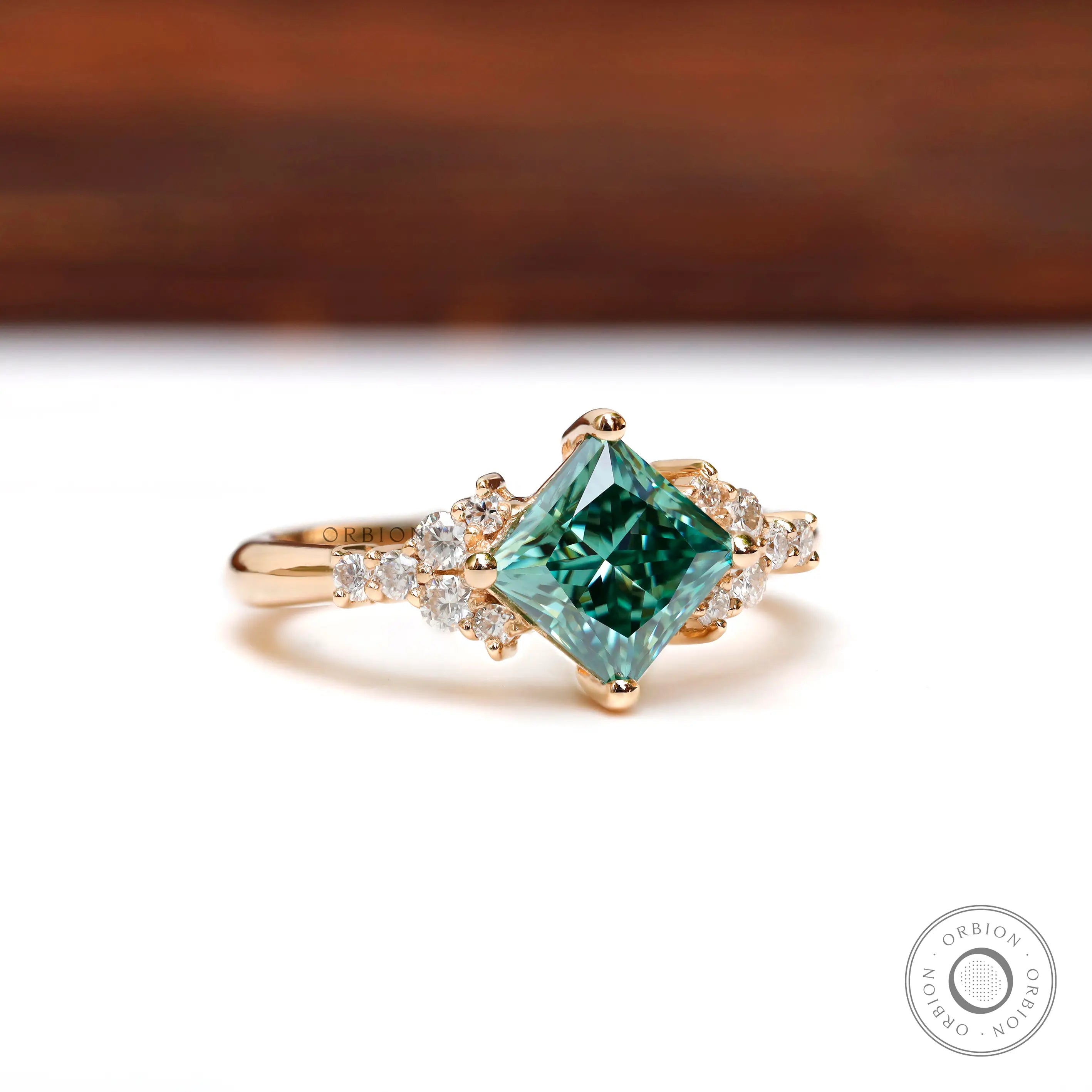 Angled view showing green moissanite with diamond accents on band