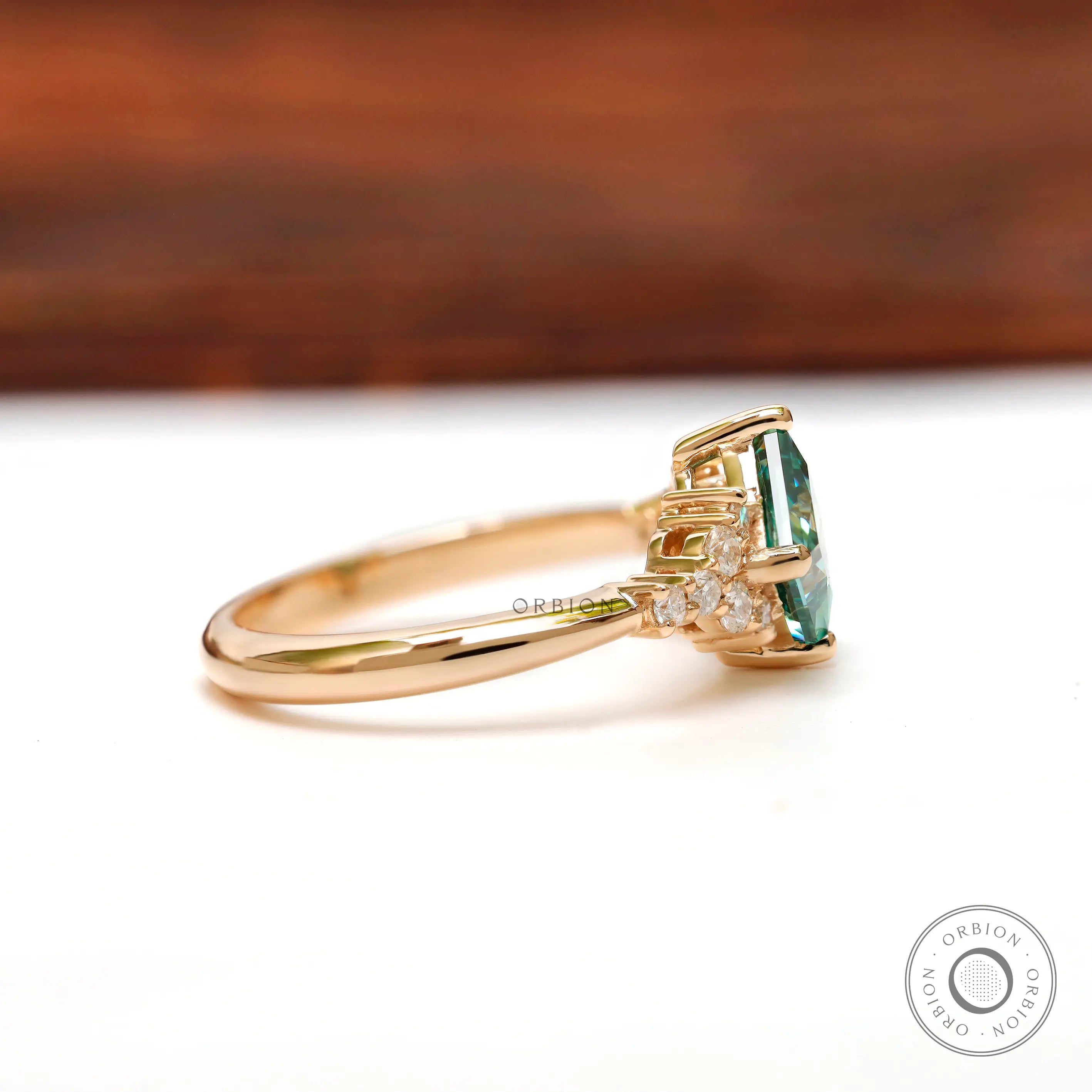 Side profile view of the green moissanite engagement ring with diamonds.