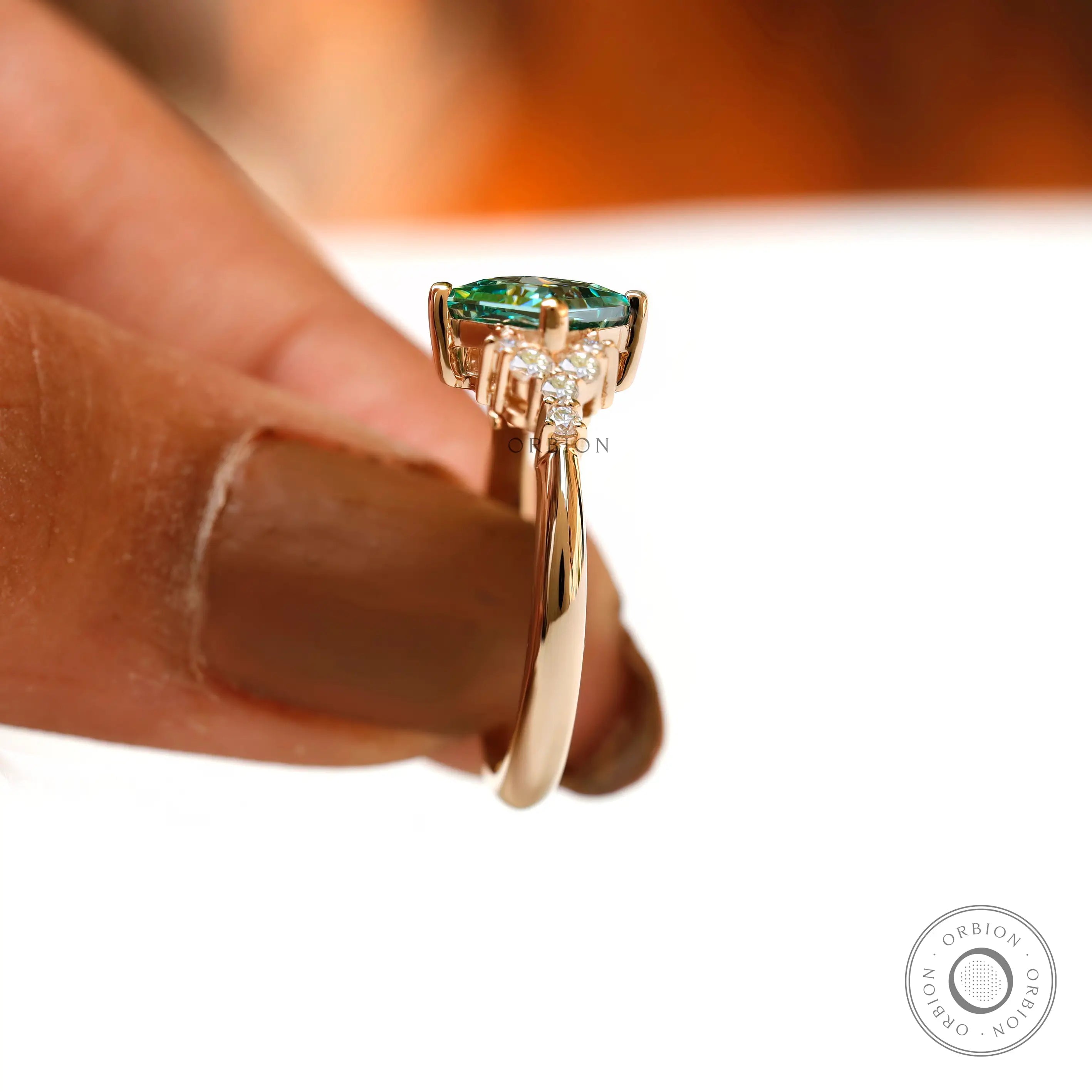Side angle view of the green moissanite ring with diamond accents