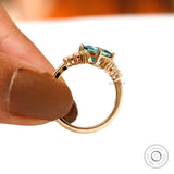 Side profile highlighting green moissanite and diamond accents.