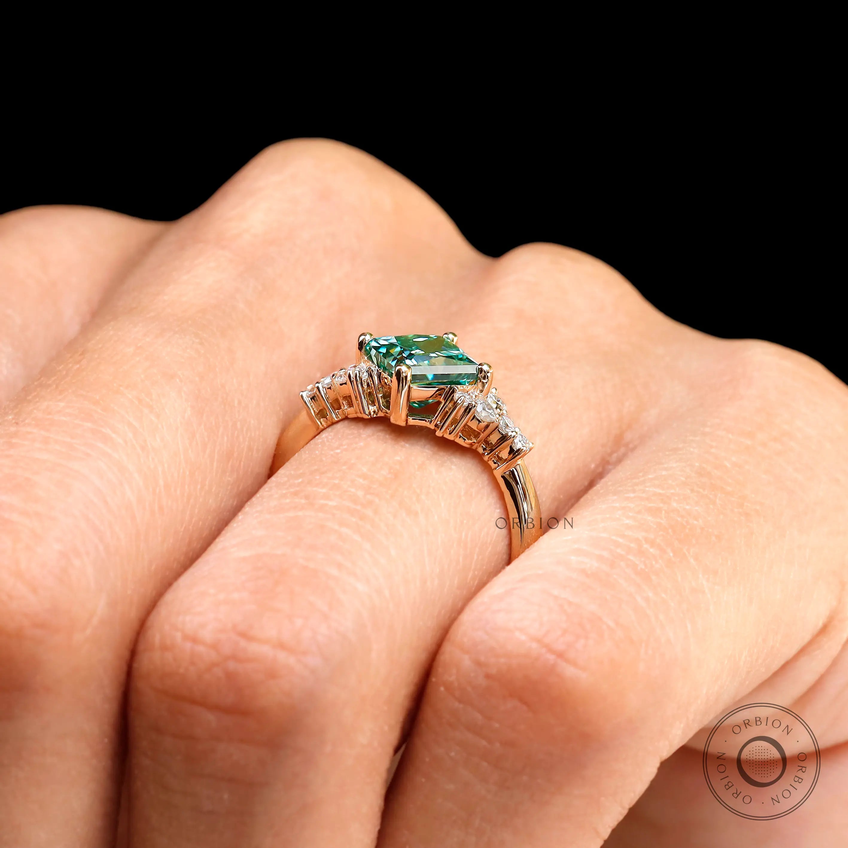 Side view showing the green moissanite engagement ring on hand.