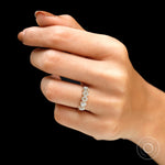On-hand side view showing scalloped prongs and sparkle across the band
