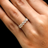 Lifestyle on-hand photo of five stone moissanite wedding band in yellow gold