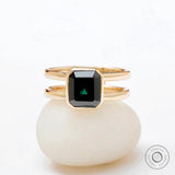 Moissanite Solitaire Elongated Asscher ring with black green stone on a white background