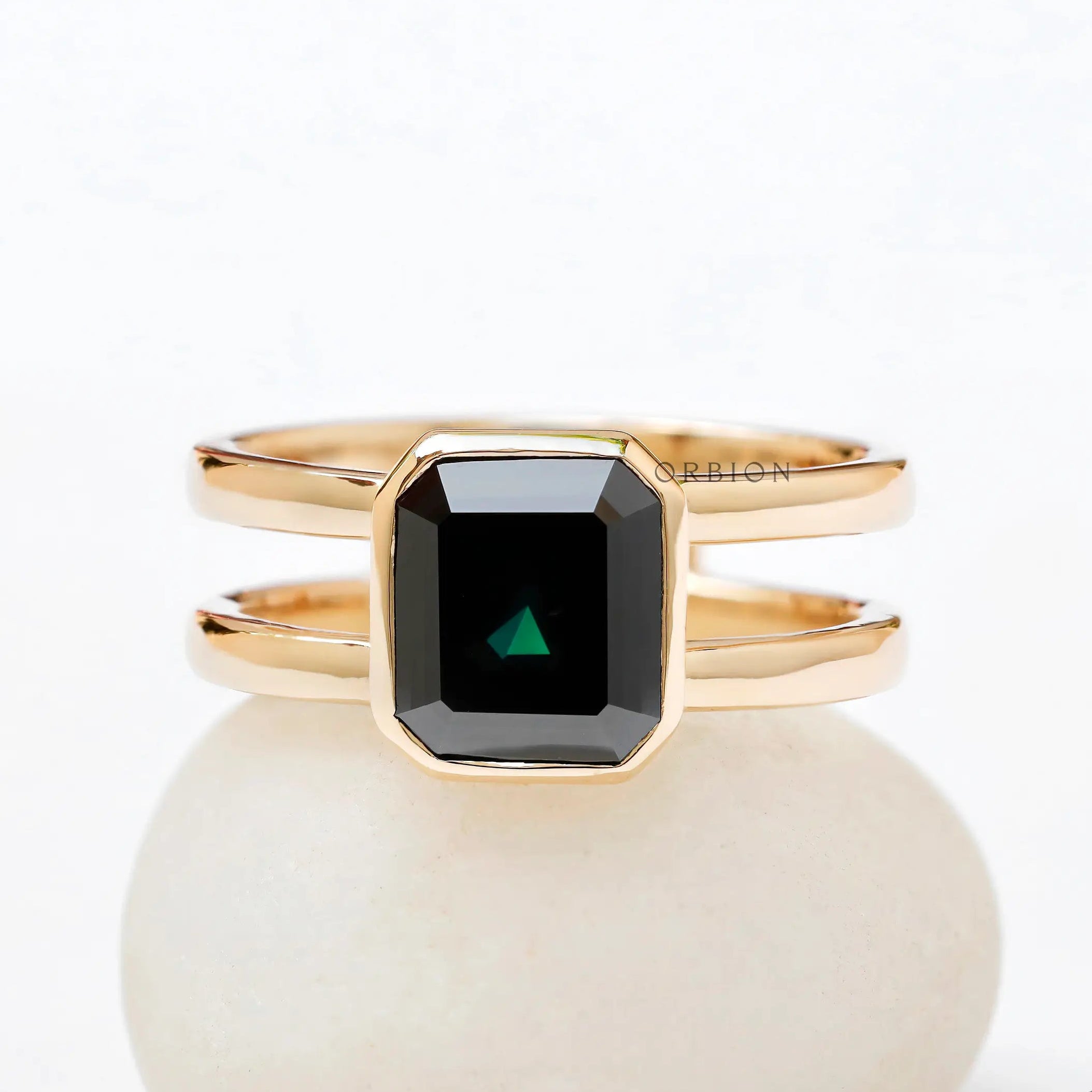 Moissanite Solitaire Elongated Asscher ring with black green stone on a white background