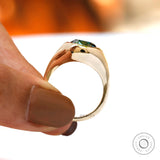 Close-up of blue green oval moissanite in bezel signet setting