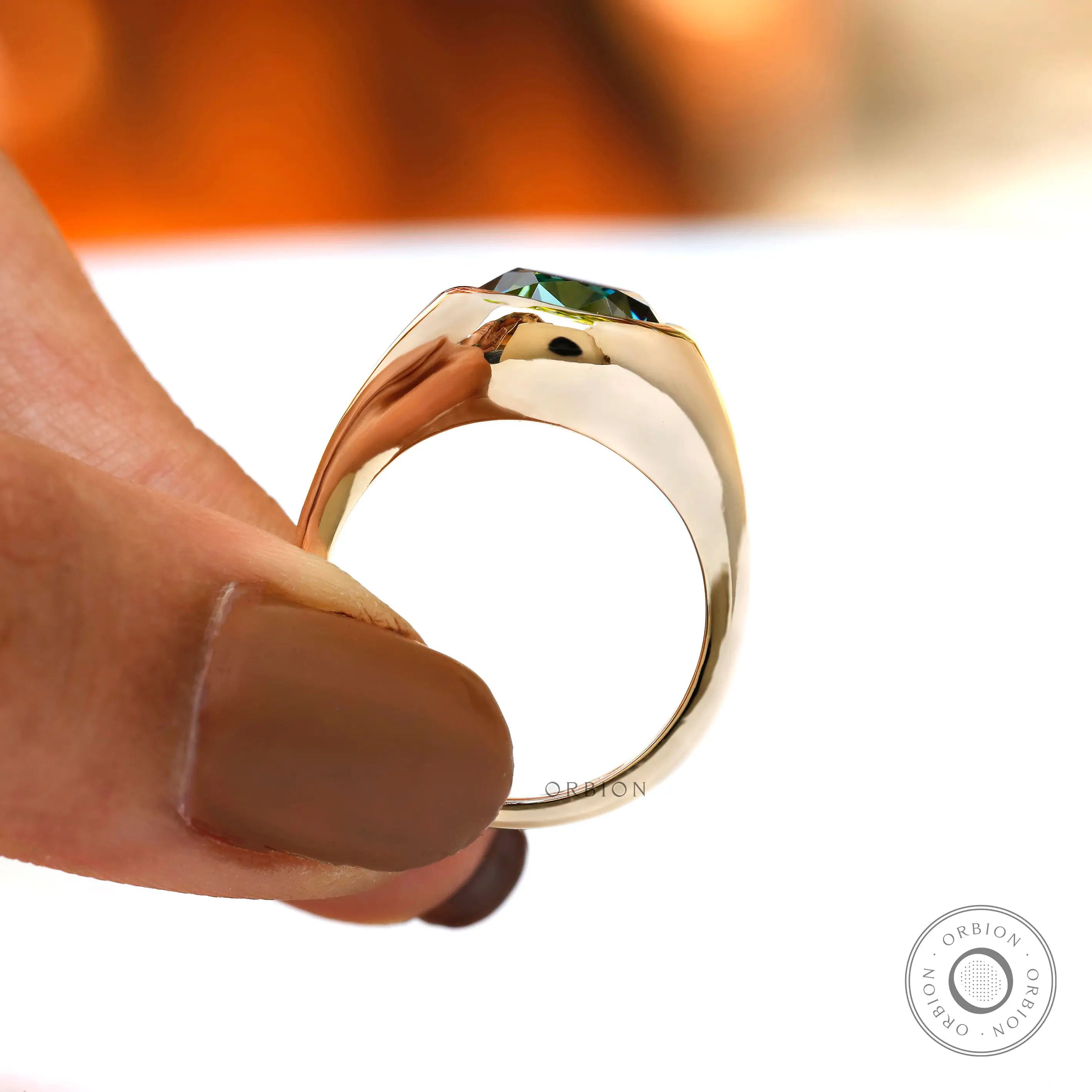 Close-up of blue green oval moissanite in bezel signet setting