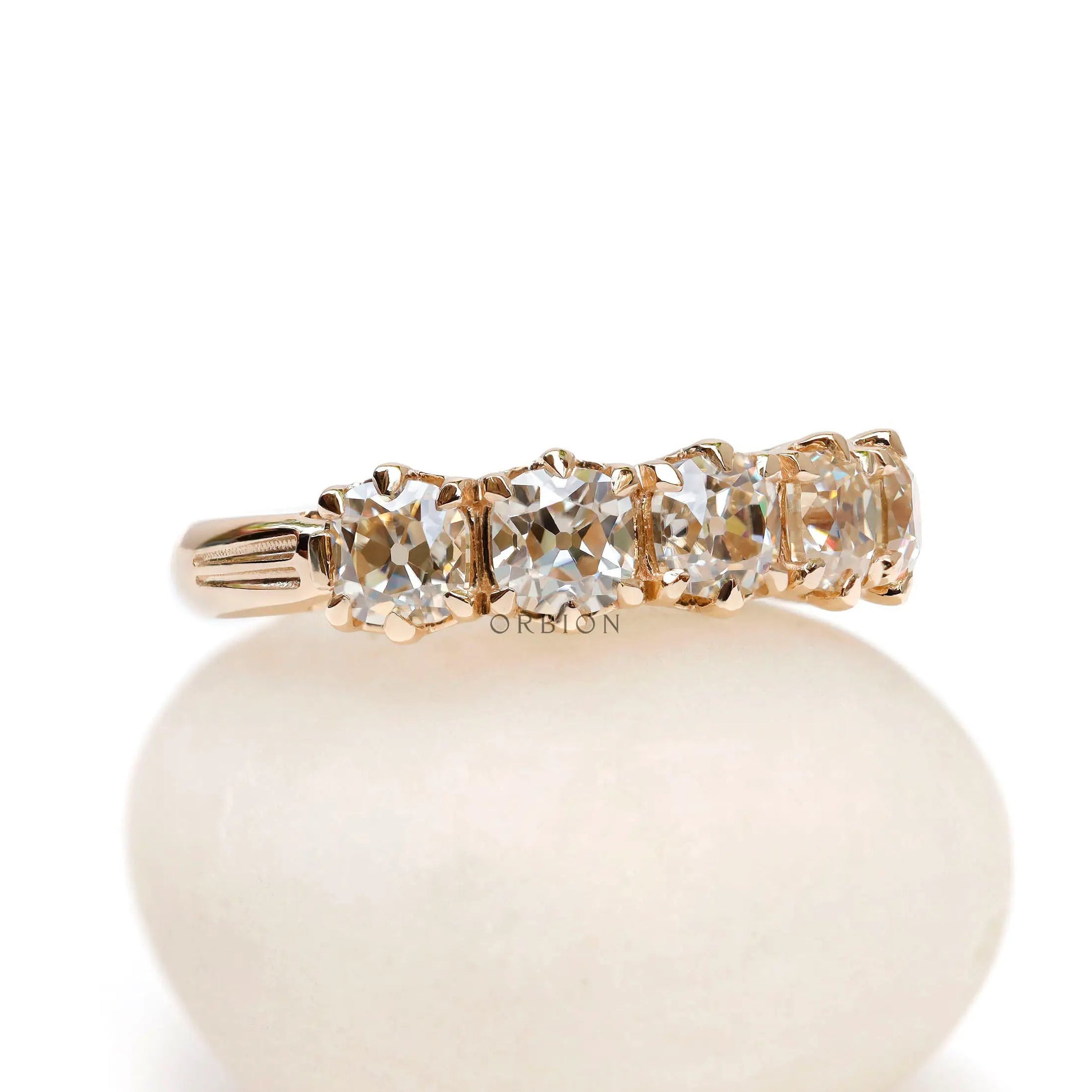 Angled view showing prong set five stone moissanite band