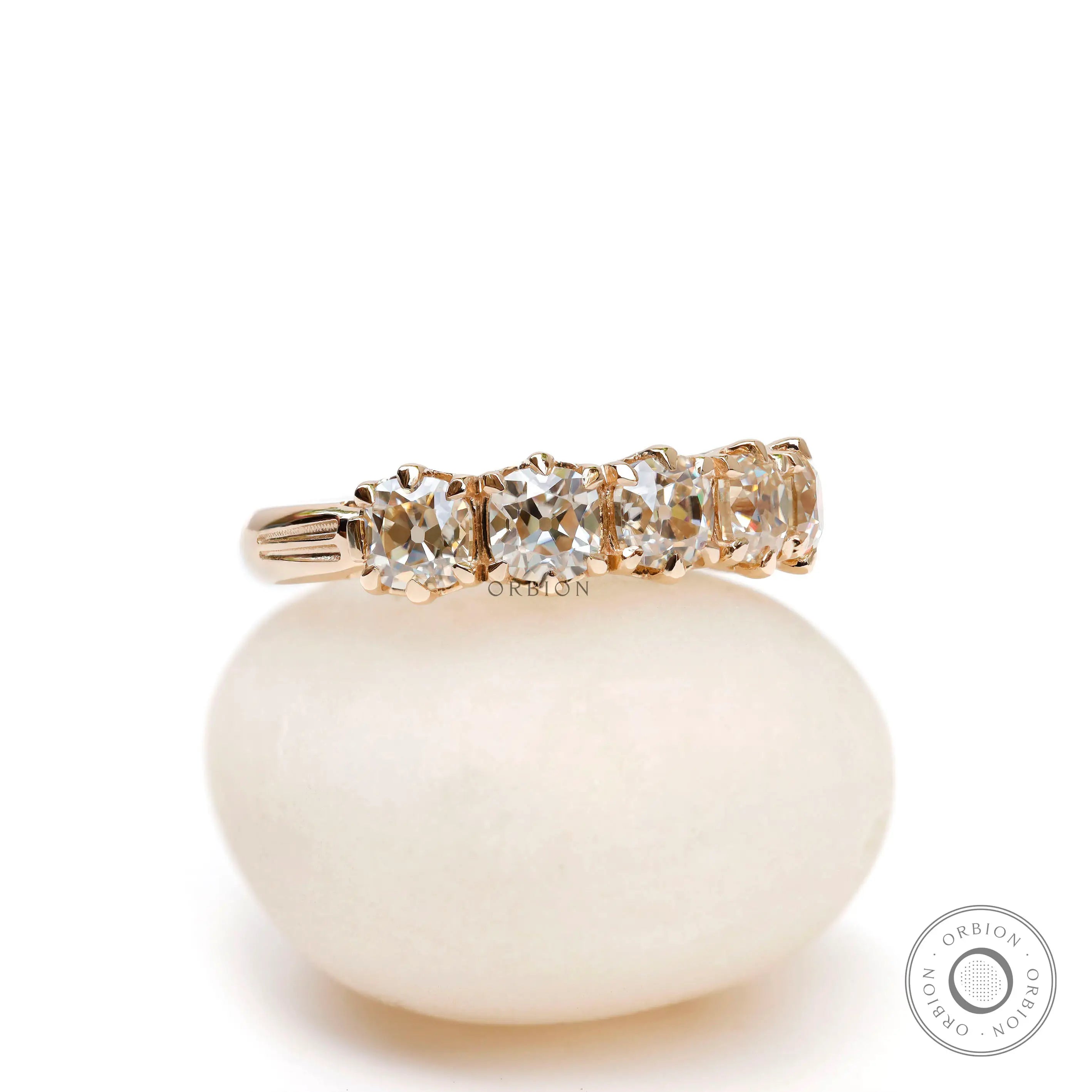 Angled view showing prong set five stone moissanite band