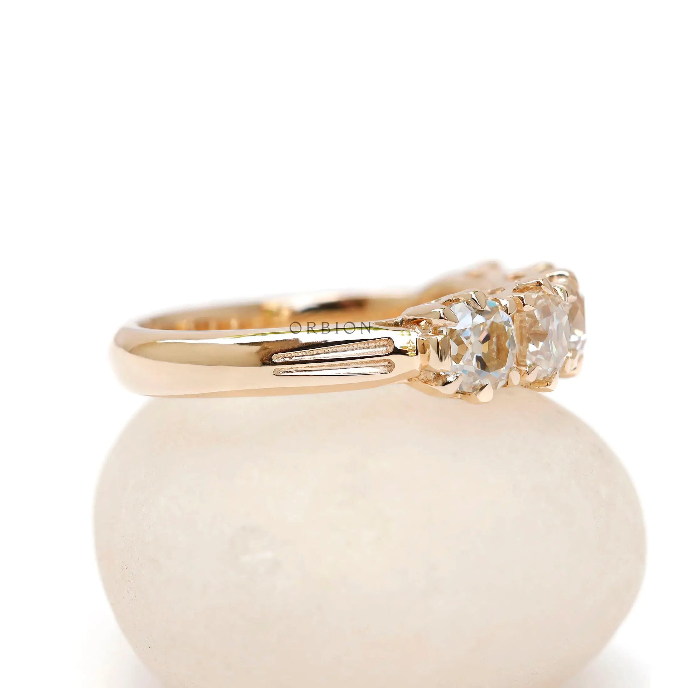 Side profile of vintage five stone moissanite band with solid gold shank