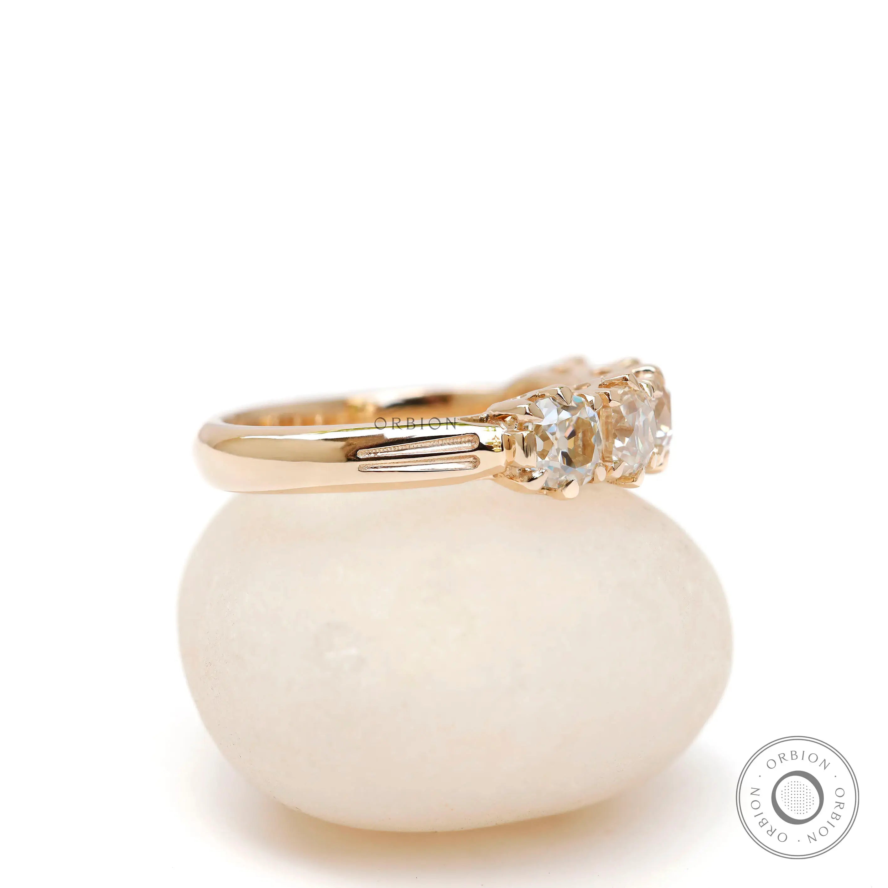 Side profile of vintage five stone moissanite band with solid gold shank