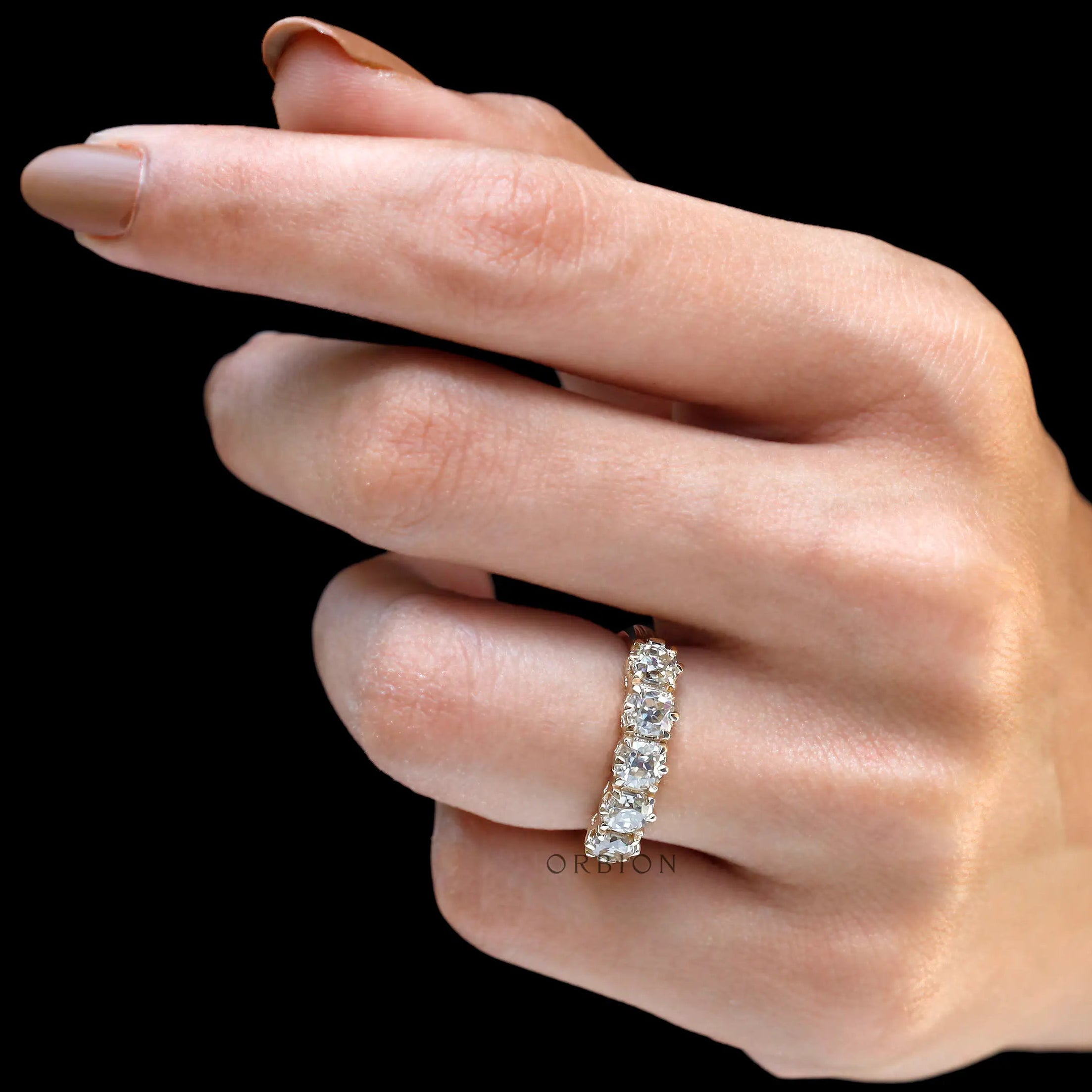Five stone moissanite band worn on hand showing scale and sparkle