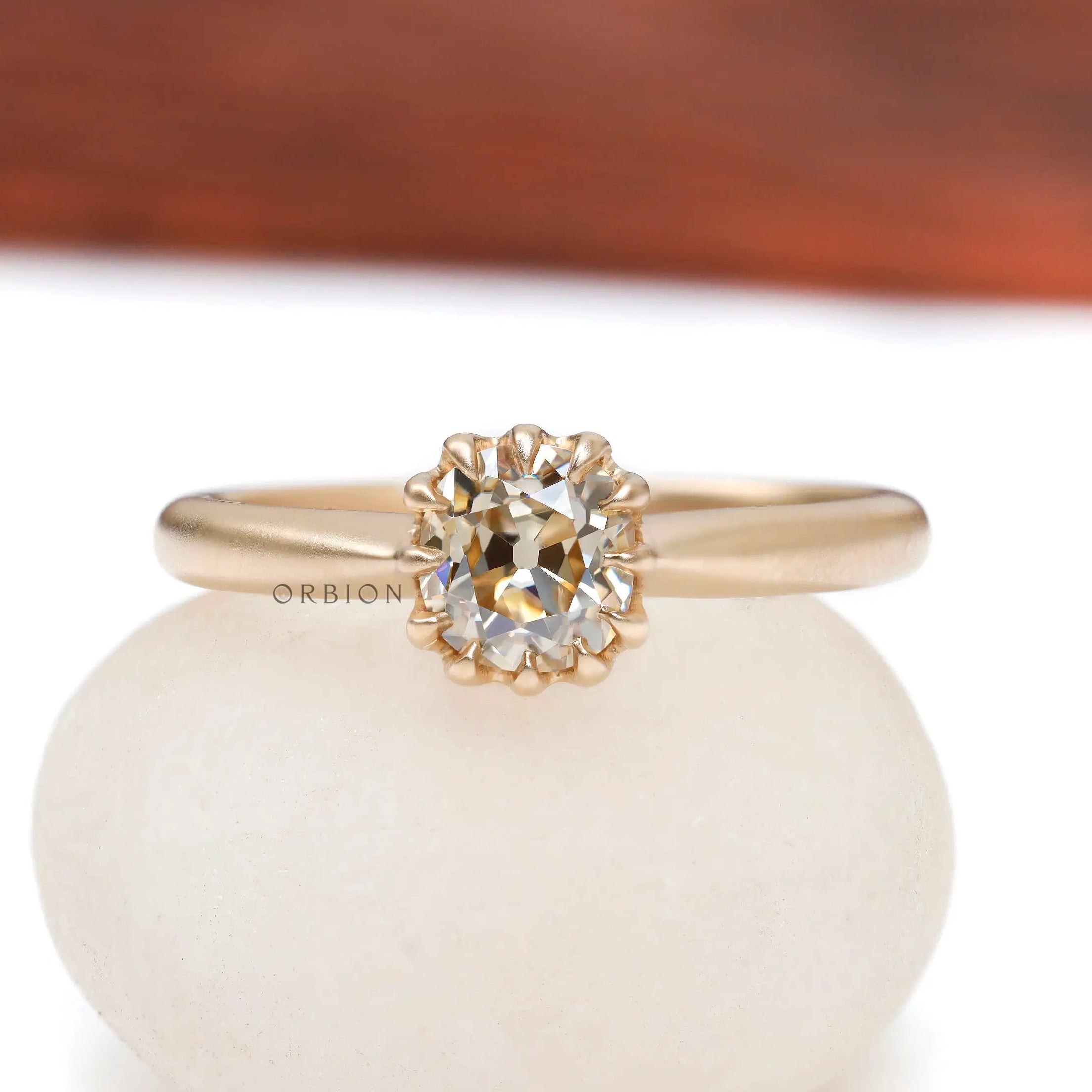 Elongated cushion Old Mine Cut light champagne moissanite solitaire ring in 10K yellow gold front view