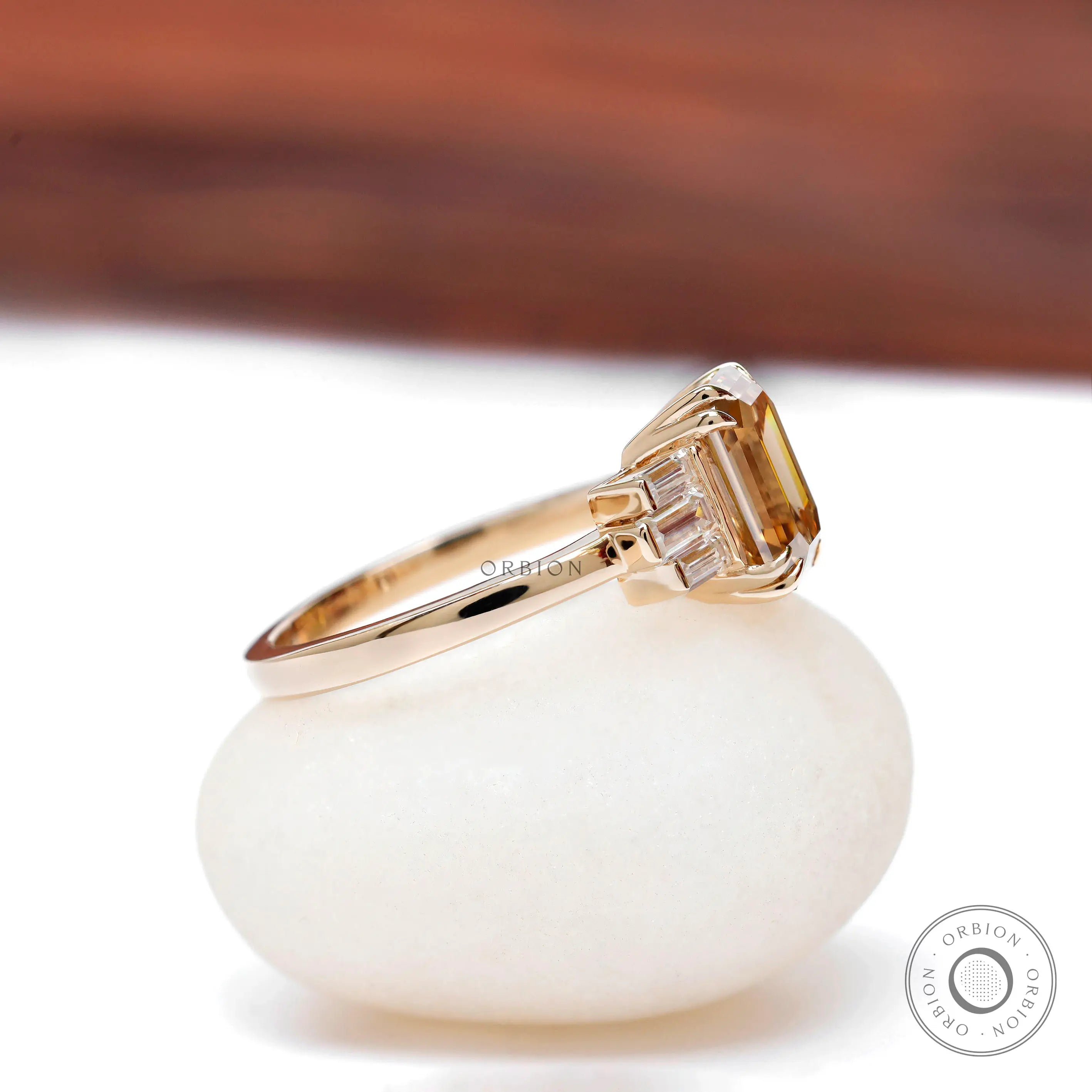 Emerald cut champagne moissanite ring with baguette diamond accents